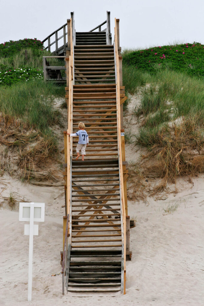 Ein Kind auf einer Treppe aus Holz.